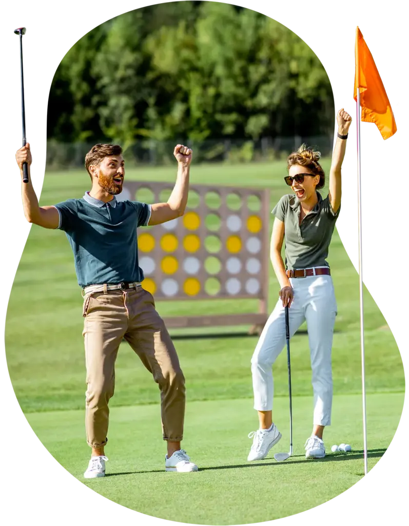 Two golfers celebrating near the hold with arms raised.